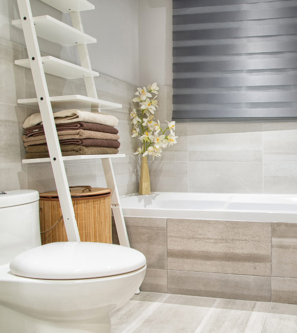 tiled bathroom with toilet and bath tub
